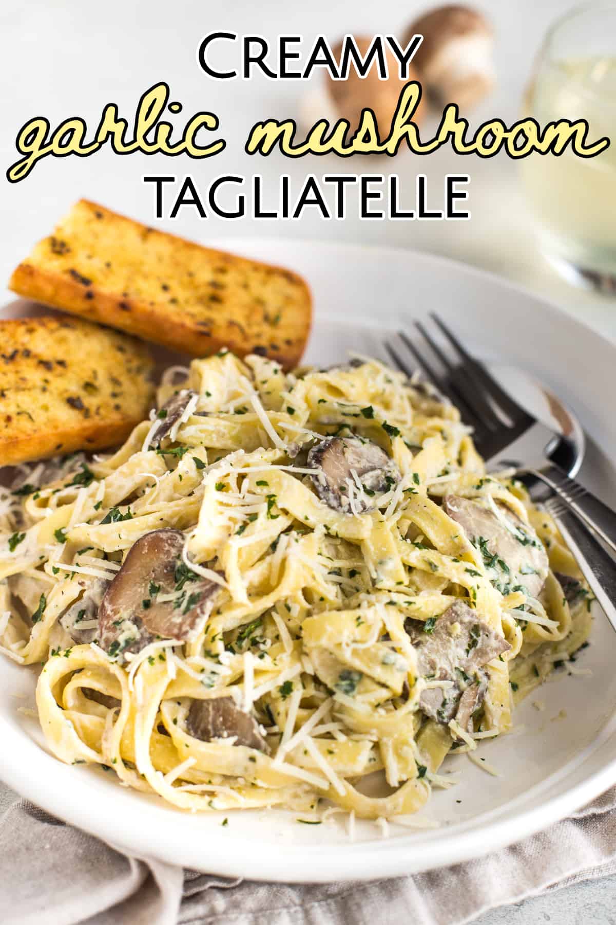 Portion of creamy garlic mushroom tagliatelle topped with parmesan and parsley.