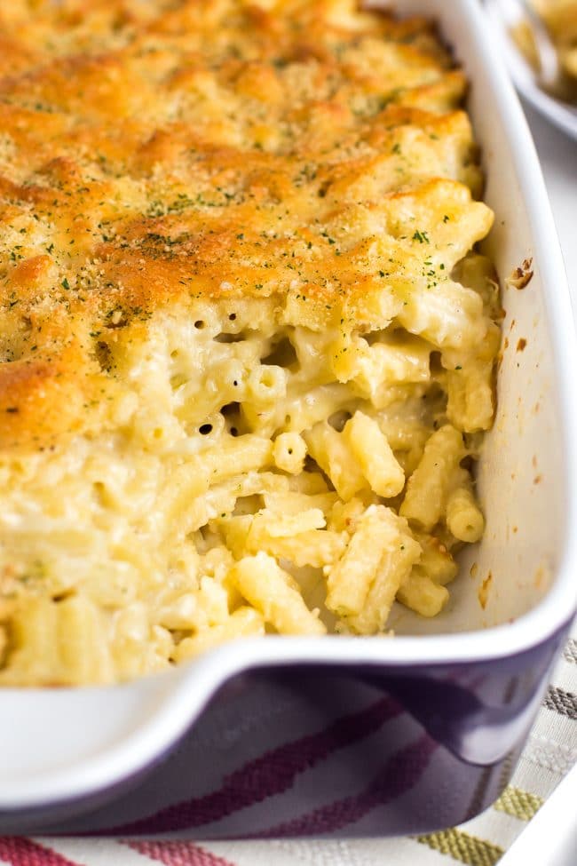 Large dish of macaroni cheese with a crispy topping, with a portion removed