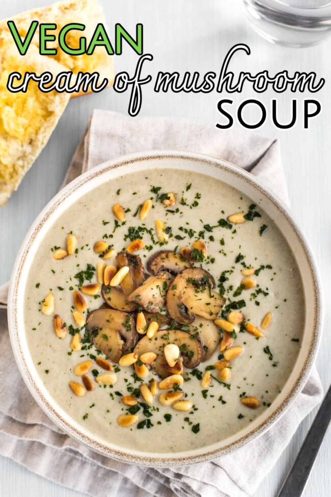 Bowl of vegan cream of mushroom soup topped with garlic mushrooms and toasted pine nuts.