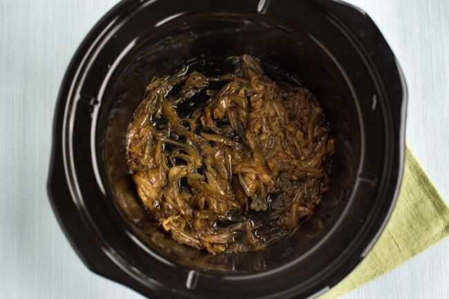 Caramelised onions in a slow cooker pot.
