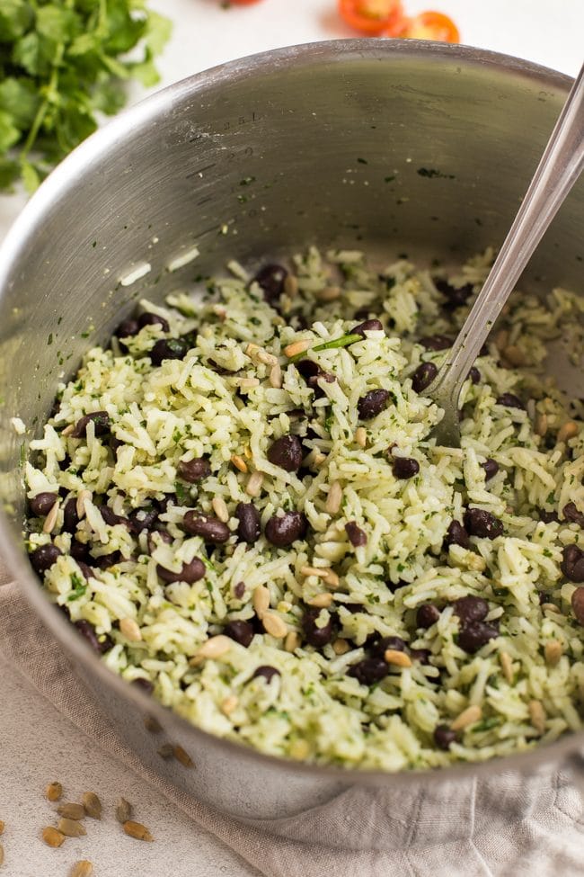 Mexican rice with cilantro pesto, black beans and sunflower seeds in a saucepan