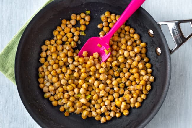 Chickpeas cooking in a frying pan.