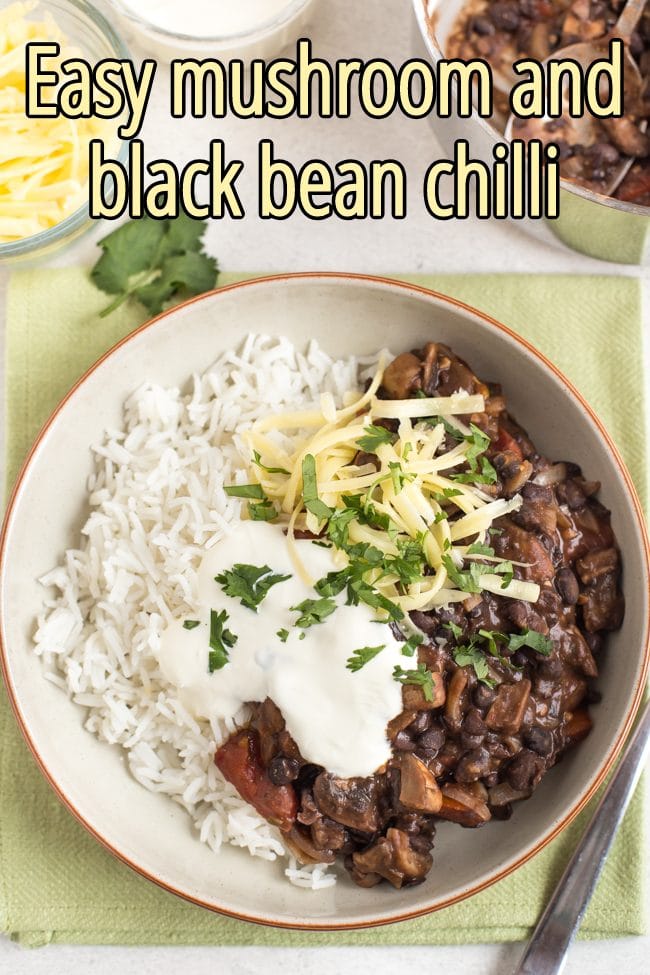 Mushroom and black bean chilli in a bowl with rice and sour cream shot from above