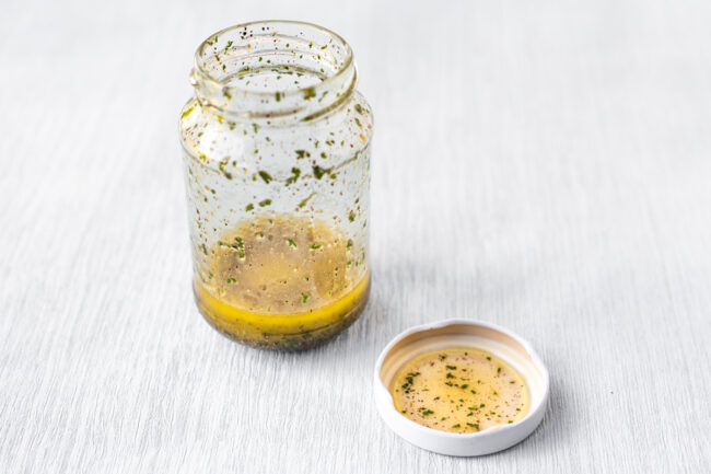 A small glass jar of lemon vinaigrette.