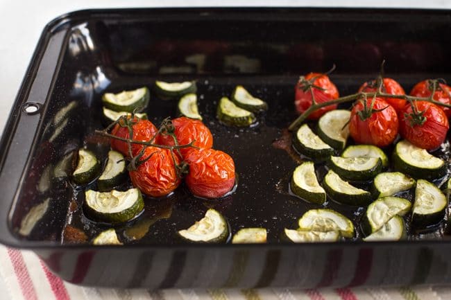 Roasted cherry tomatoes and courgette in a baking tray