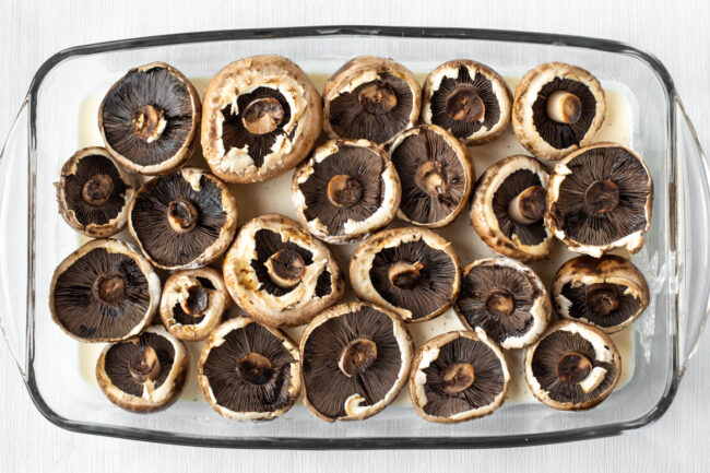 Baby portobello mushrooms laid out in a baking dish.