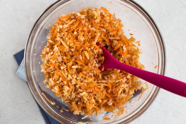 Grated carrot, grated cheese and breadcrumbs in a mixing bowl.