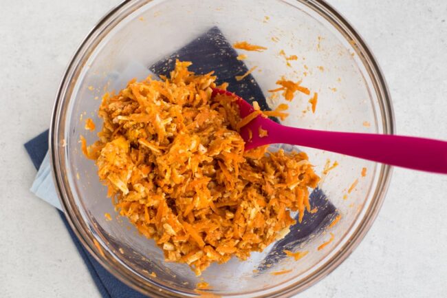 Grated carrot mixture in a mixing bowl.