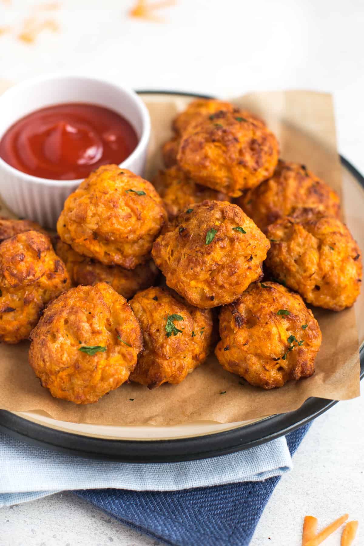 Cheesy carrot bites on a plate with ketchup.