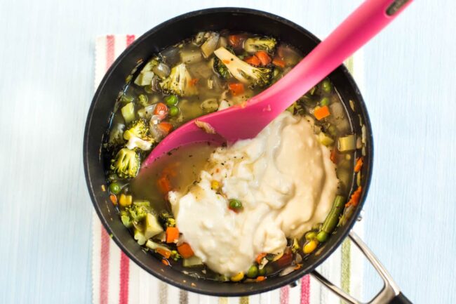 Vegetable soup with creamy white sauce in a pan