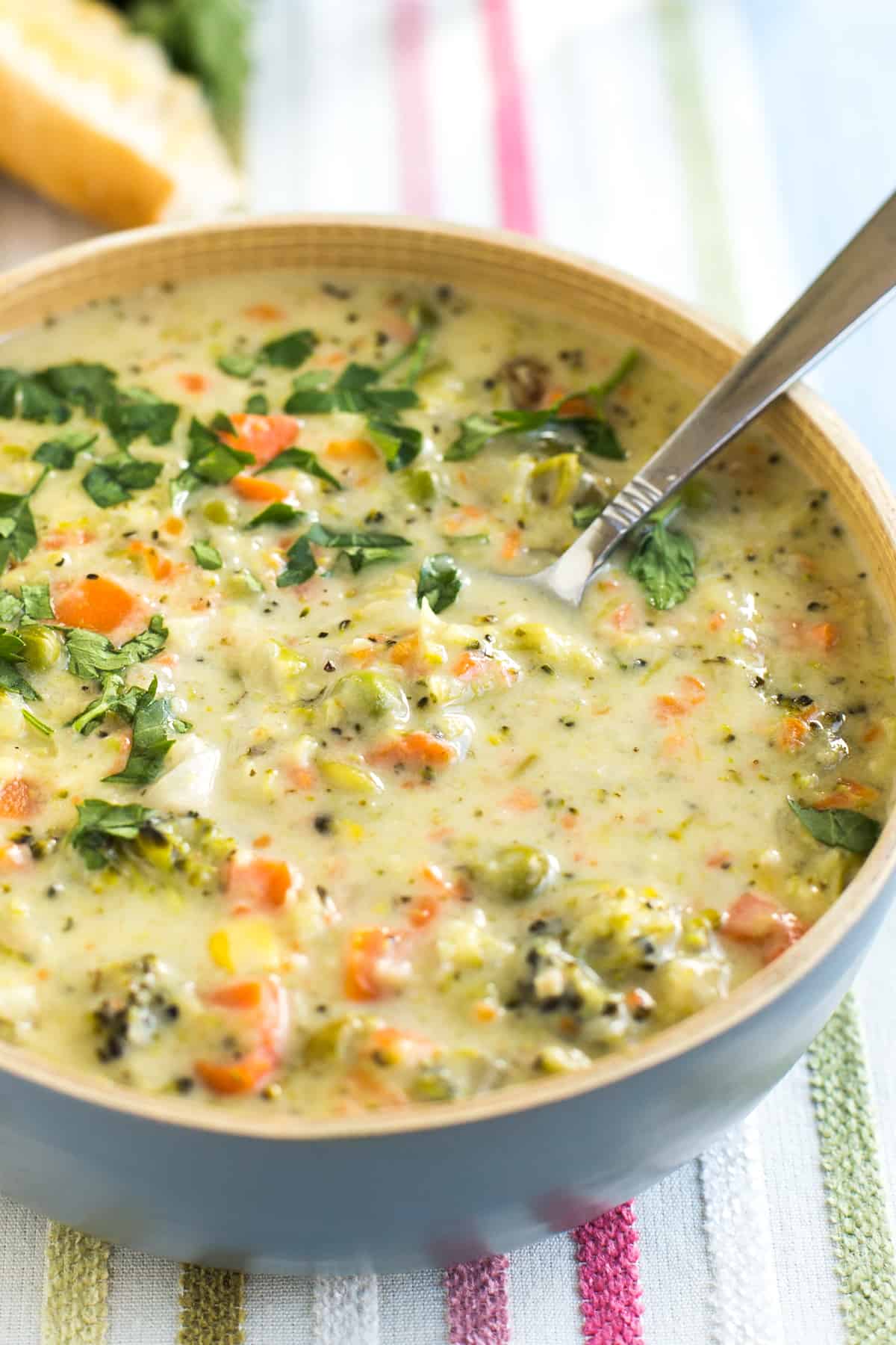 Bowlful of creamy veggie pot pie soup with a spoon