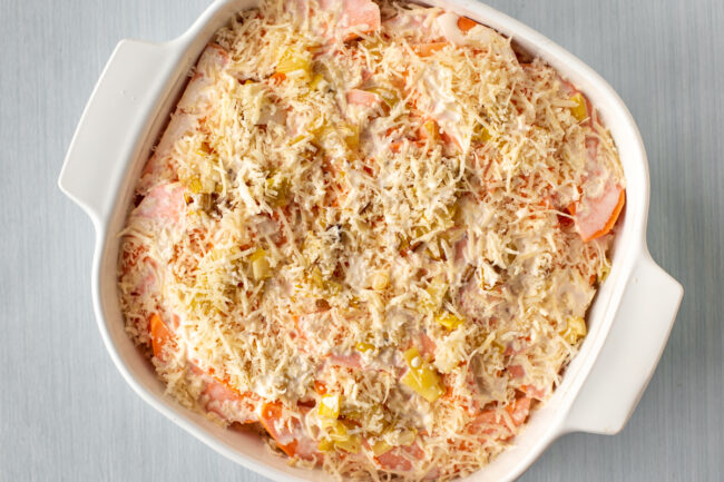 Uncooked sweet potato gratin in a baking dish.