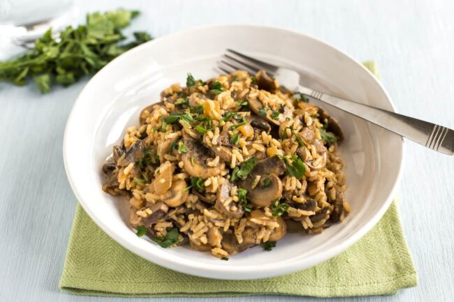 Portion of creamy mushroom stroganoff mixed with rice in a bowl