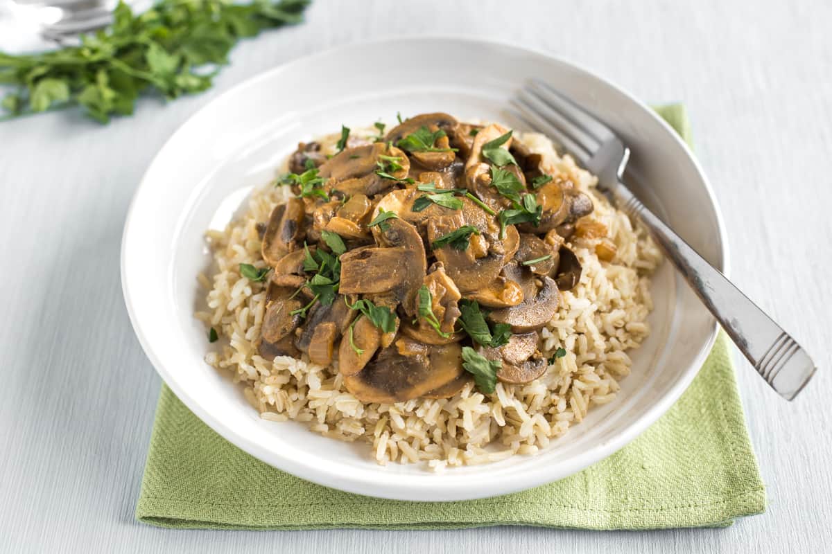 Portion of creamy mushroom stroganoff served on a bed of rice