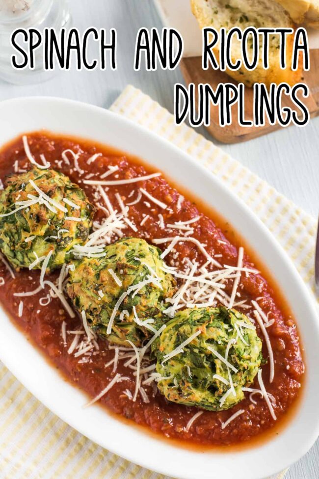Portion of spinach and ricotta dumplings on a plate with tomato sauce and cheese