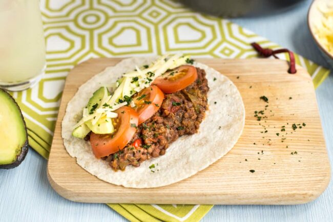 Lentil and quinoa tacos on a board.