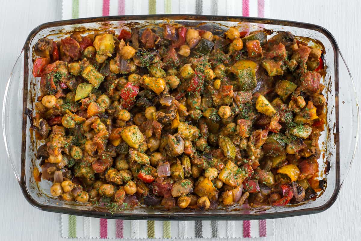 Roasted vegetable ratatouille with chickpeas in a baking dish in a rich tomato sauce