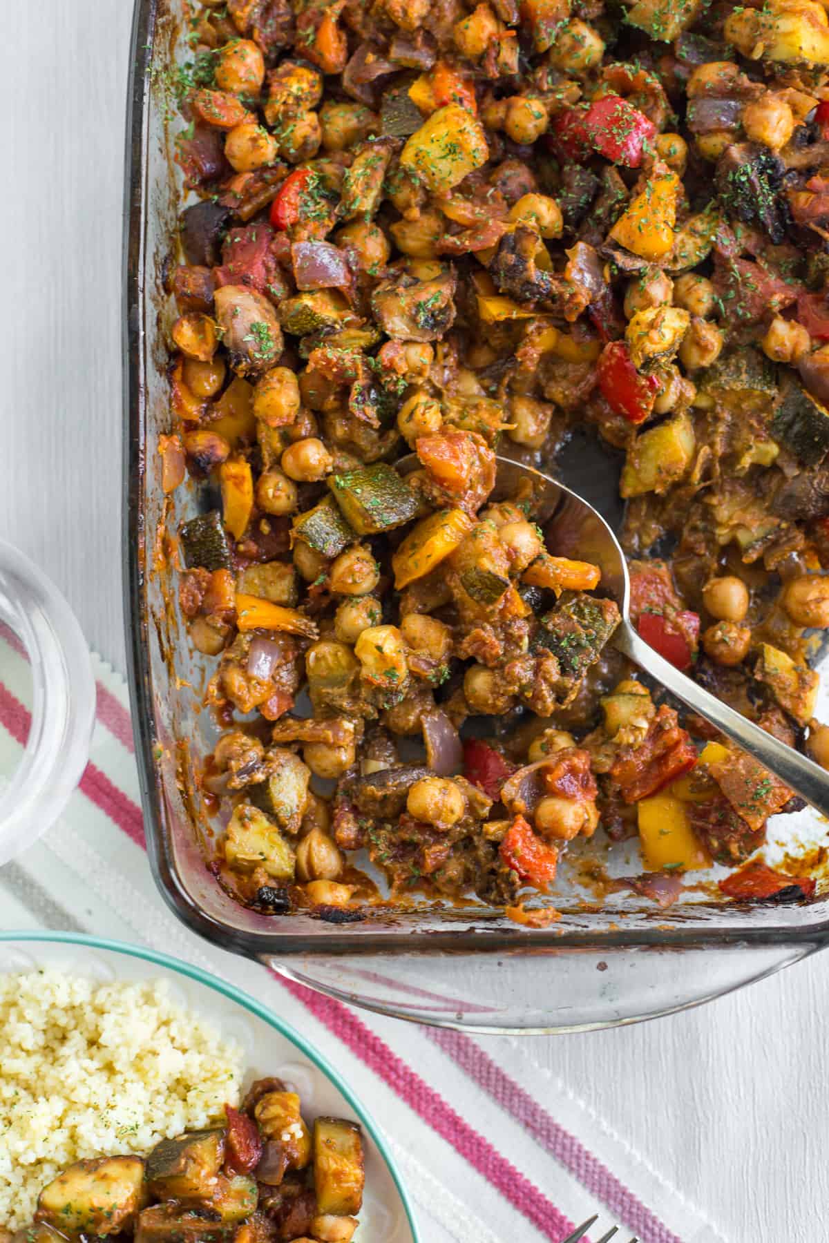 Roasted vegetable ratatouille in a baking dish with a spoon