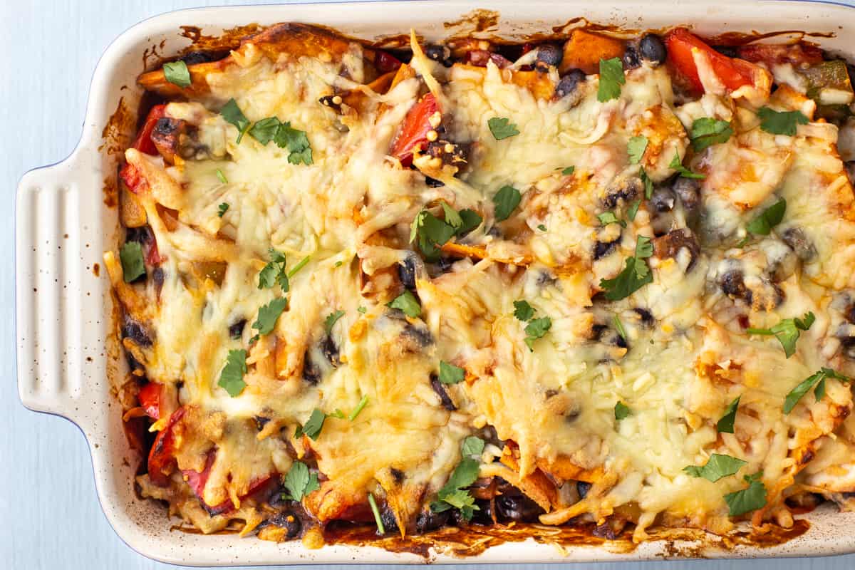 Enchilada casserole in a baking dish with a crispy cheese topping.