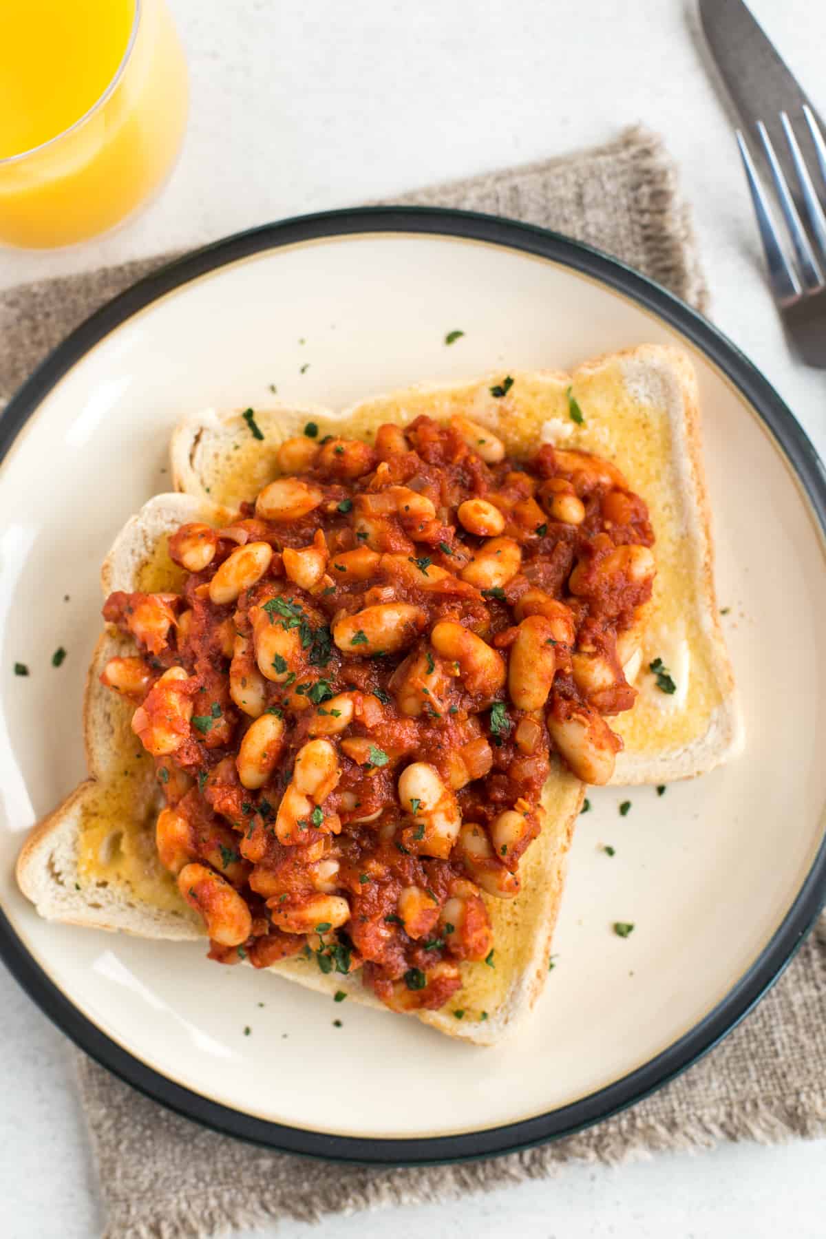 Homemade vegan baked beans served on two slices of buttered toast.