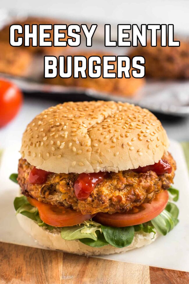 Cheesy lentil burger in a roll with tomato and lettuce.