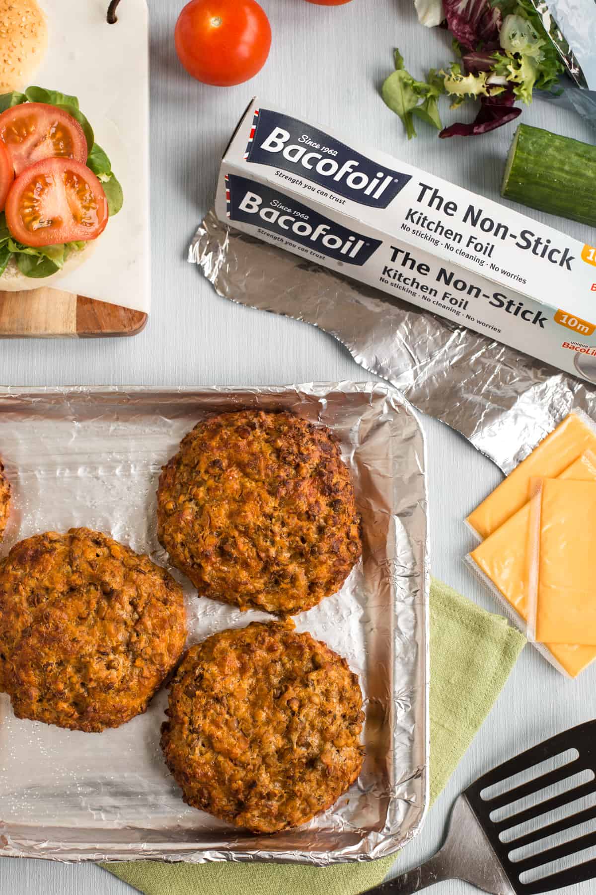 Cheesy lentil burgers on a baking tray, shot from above.