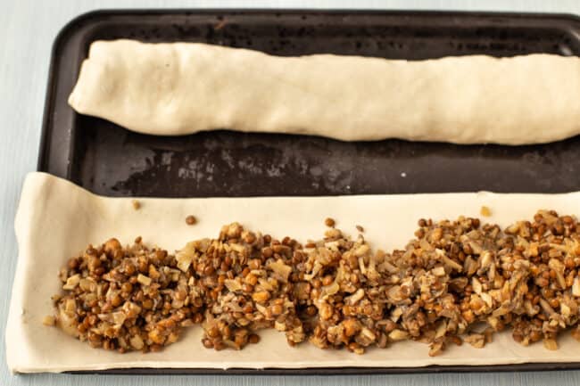 Lentil and mushroom mixture laid out on top of a strip of uncooked puff pastry.