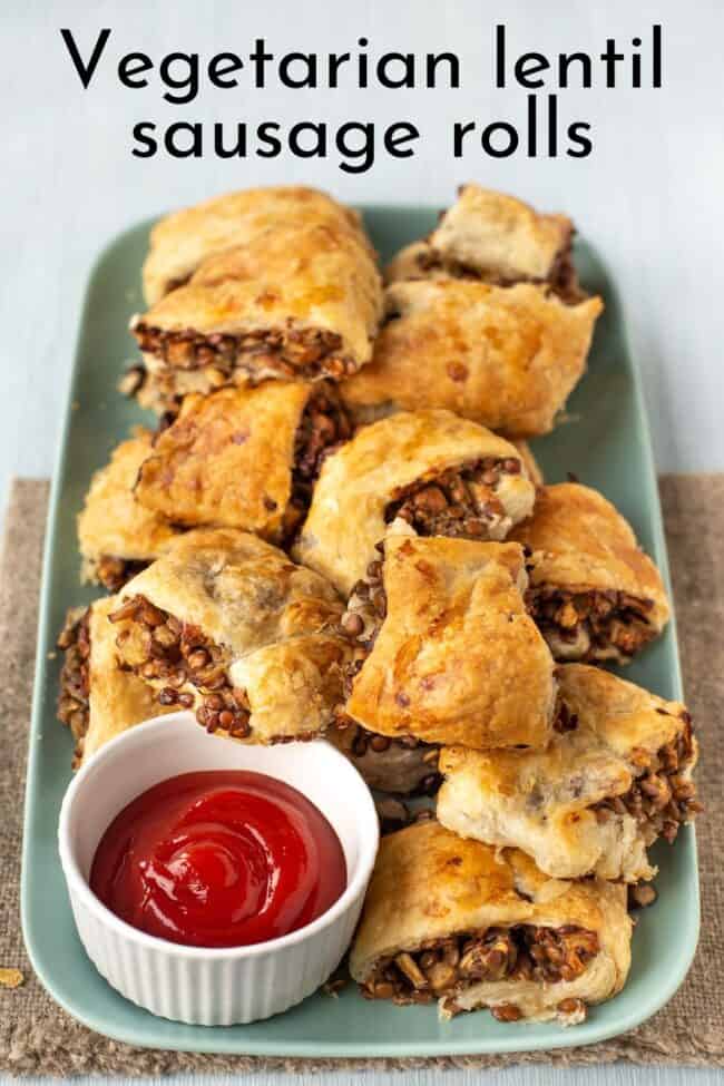 A plateful of vegetarian lentil sausage rolls with a pot of ketchup.
