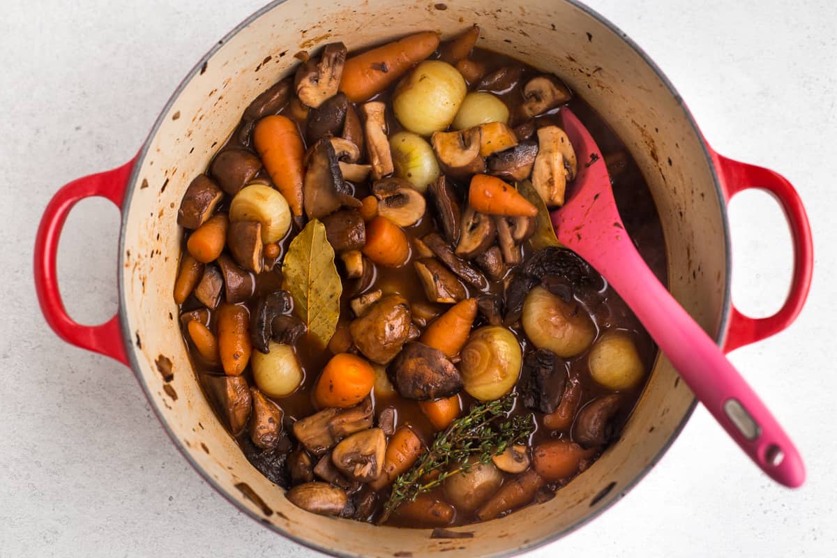 Mushroom bourguignon with carrots and onions in a large casserole dish.