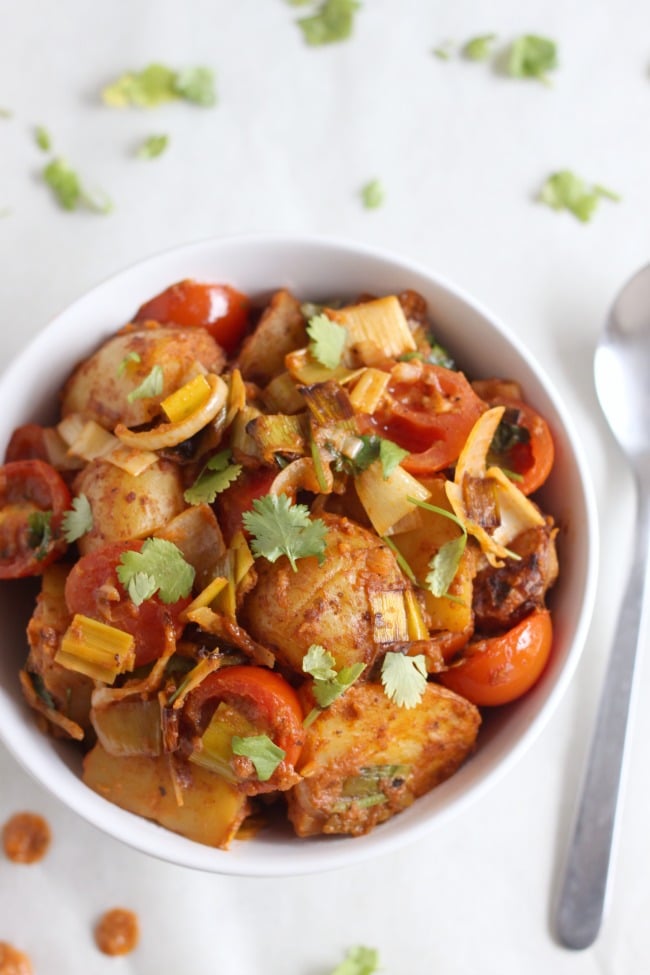 Roasted potato tikka masala - a super tasty side dish that's great hot or cold (with juicy roasted tomatoes, leeks and loads of fresh coriander!)