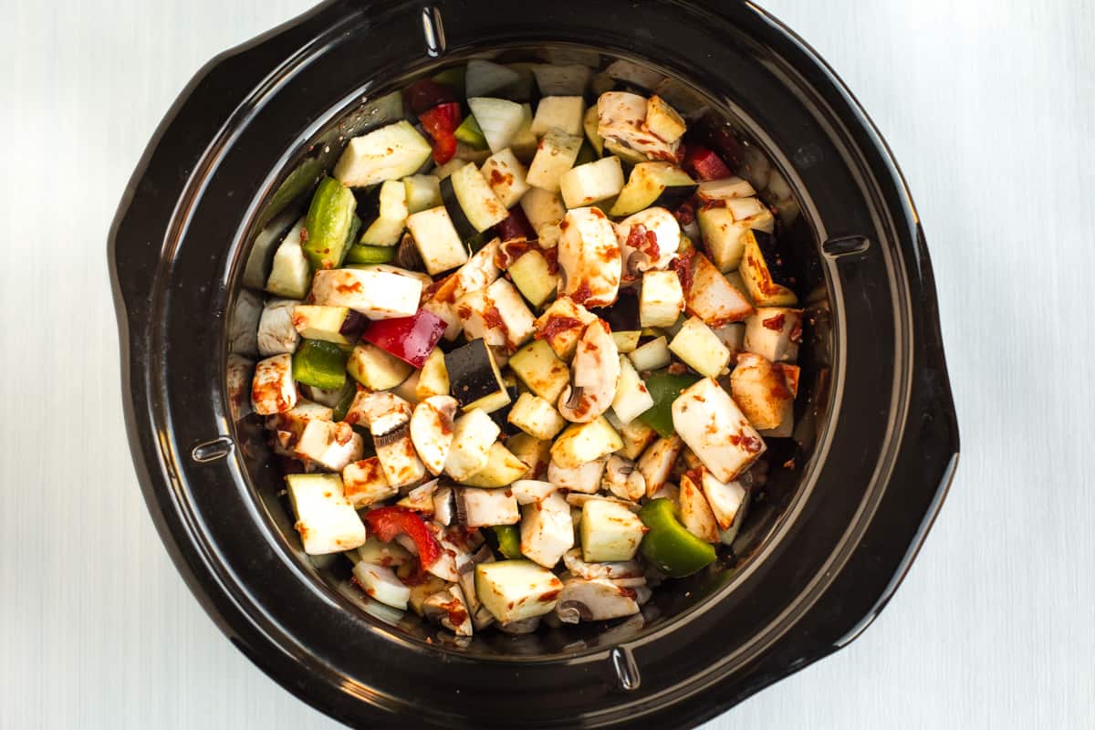 Chopped Mediterranean vegetables in a slow cooker pot.