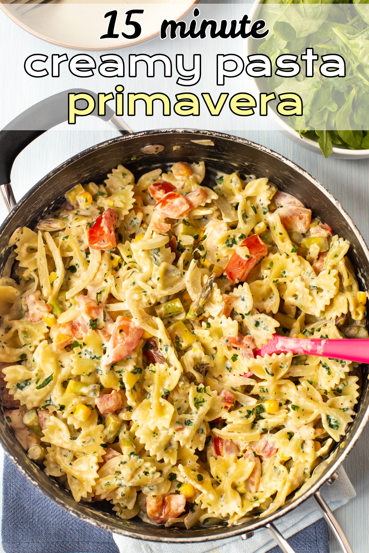 Pasta primavera with vegetables and a creamy sauce in a pan.