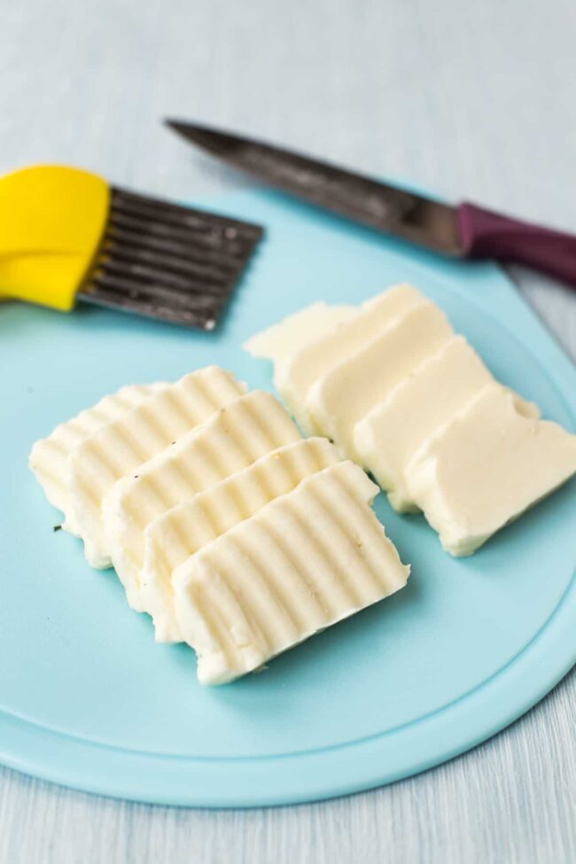 Halloumi cheese sliced with a crinkle cutter, spread out on a chopping board.