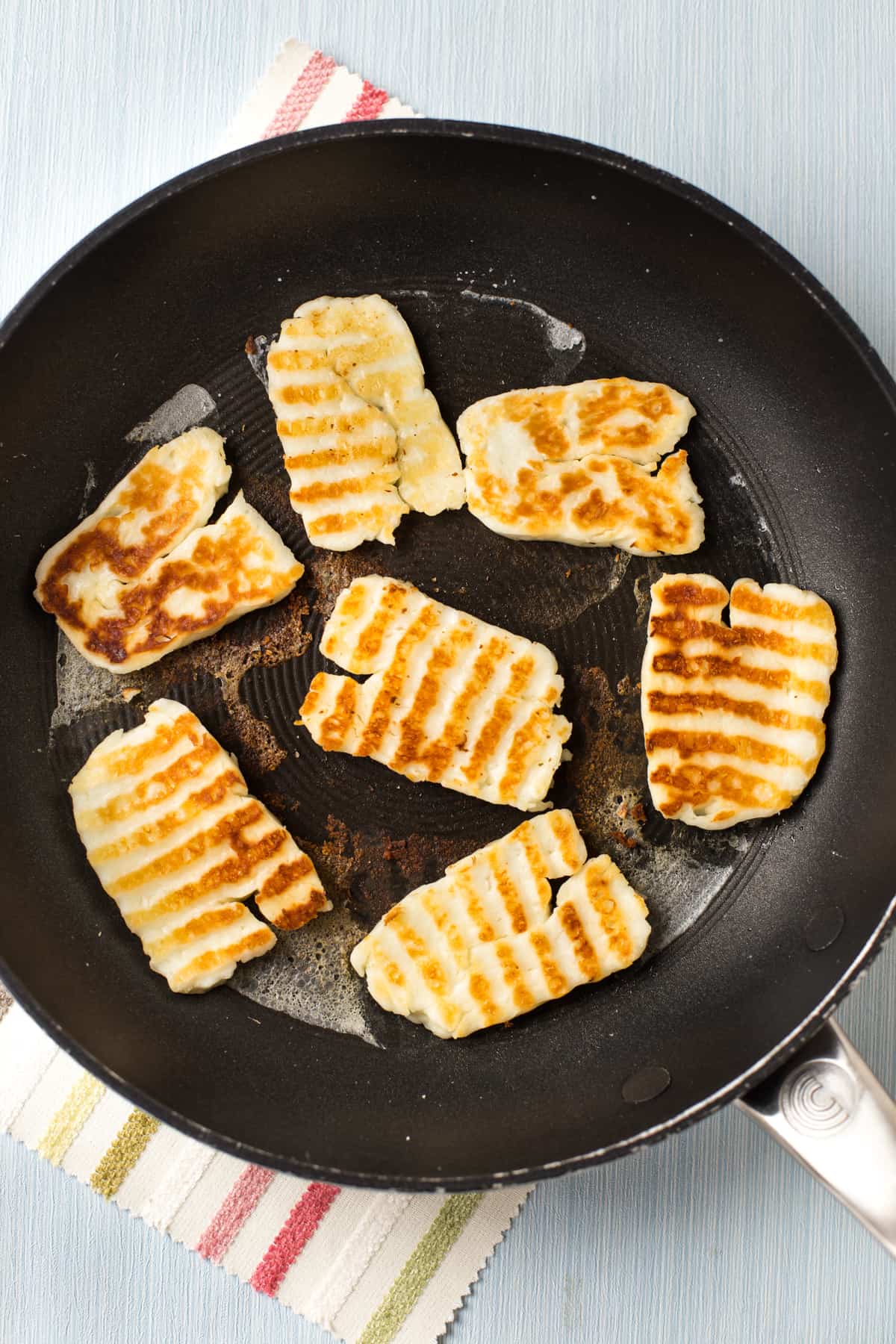 Slices of crispy halloumi cheese with golden brown griddle marks.