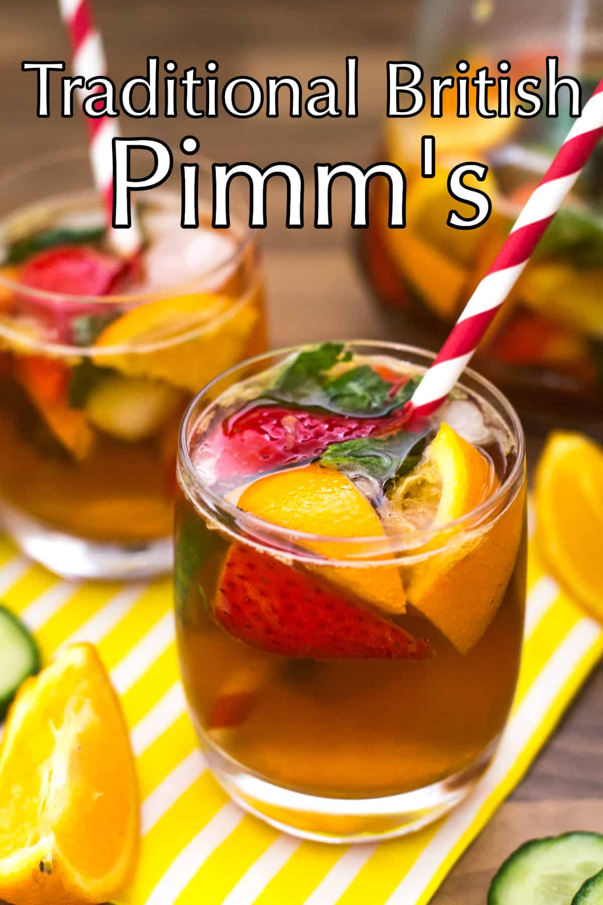 A glass of Pimm's with oranges, strawberries and mint, served with a stripey straw.