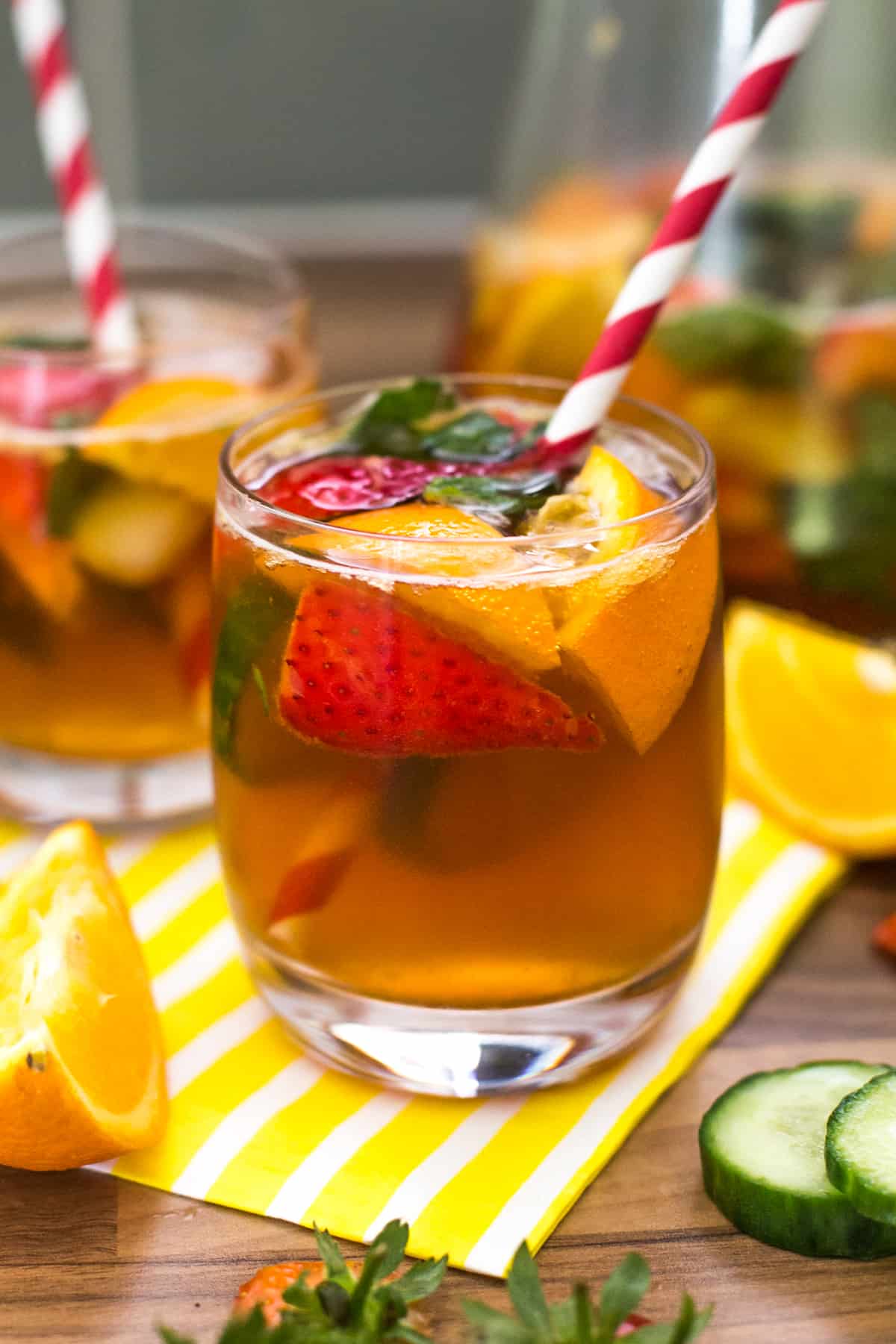 A small glass of Pimm's with strawberries, cucumber and oranges.