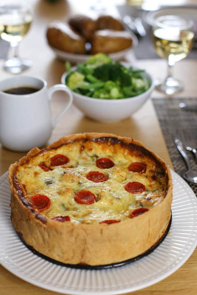 Cauliflower cheese tart - this irresistible tart combines a light and cheesy filling with juicy roasted tomatoes and flaky shortcrust pastry. A dreamy dinner party treat!