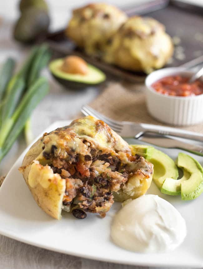 Mexican black bean stuffed potatoes - an easy way to make potatoes the star of the show! Stuffed with black beans and salsa, and topped with plenty of cheese. A fab vegetarian dinner!