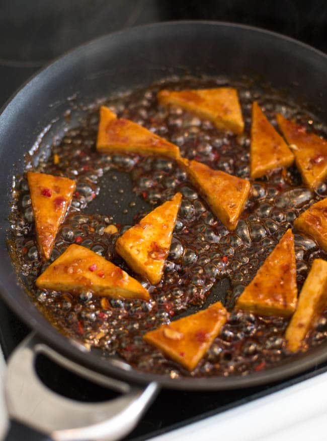 Sticky sweet chilli tofu - a quick, easy and delicious vegetarian / vegan dinner! Cook the tofu until crispy, then add the sauce and let it get nice and sticky!