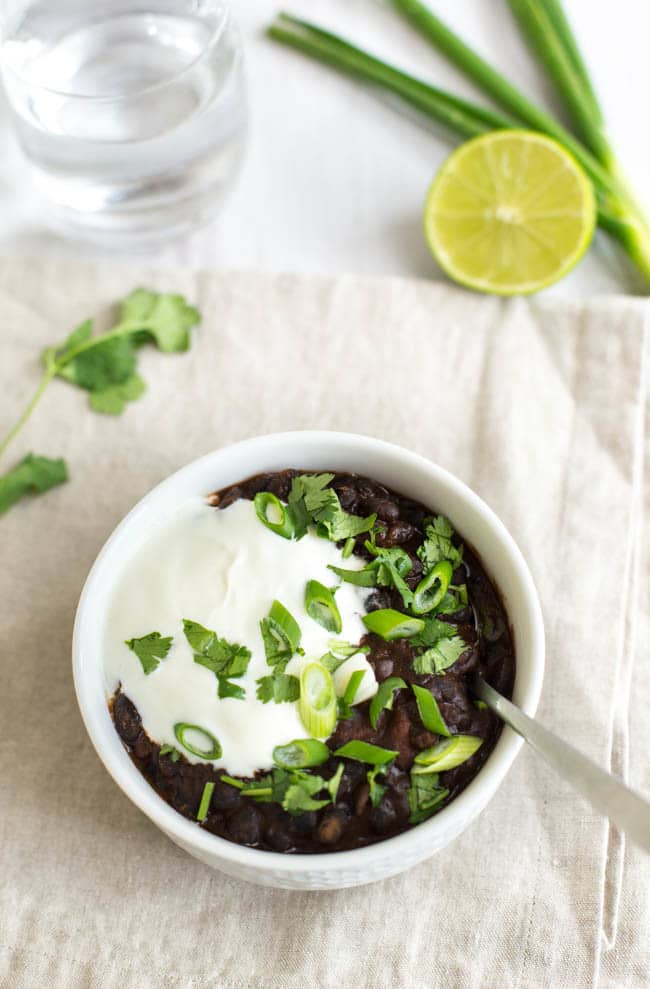 Black bean soup topped with sour cream and spring onions.