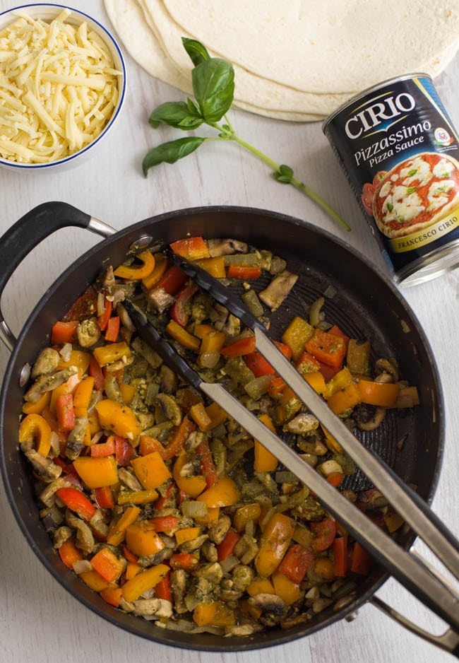A frying pan of Mediterranean-style vegetables and pesto.