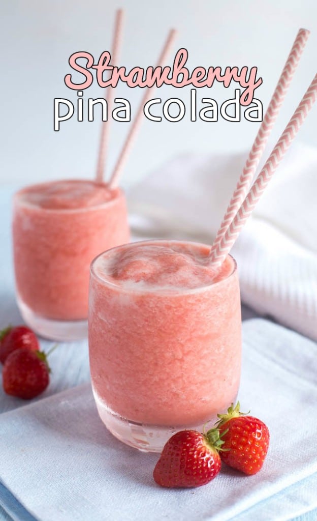A glass of strawberry pina colada with straws and fresh strawberries.