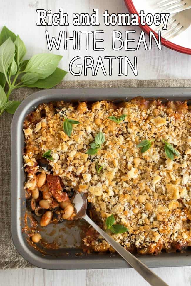 A white bean gratin in a baking dish, with a spoon scooping out one corner.