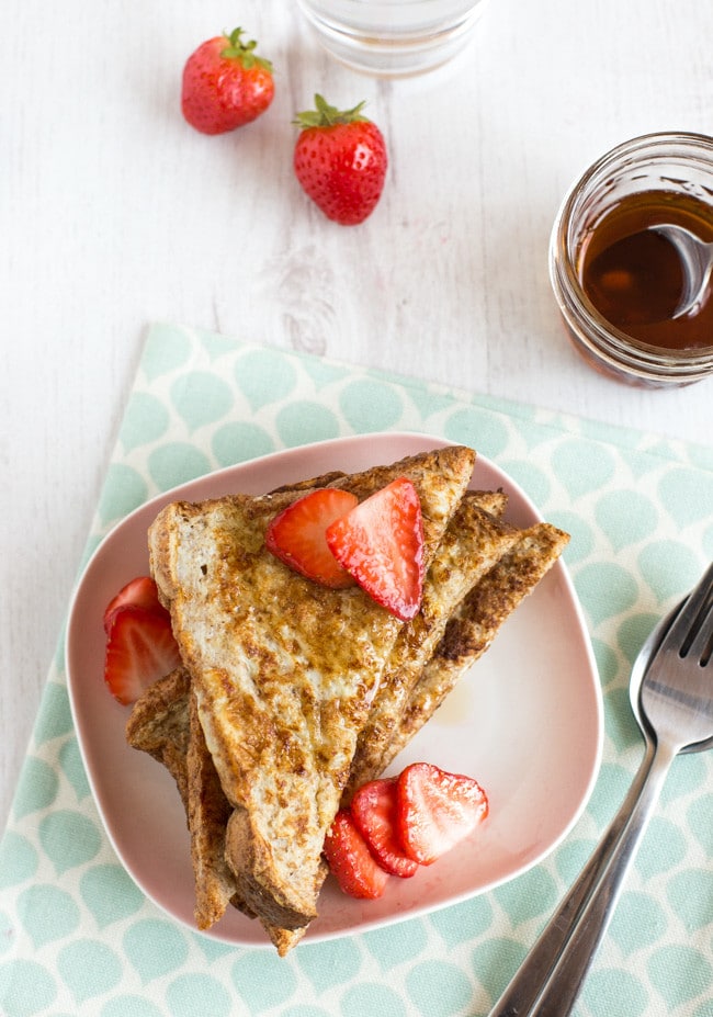 A stack of wholewheat French toast topped with fresh strawberries.