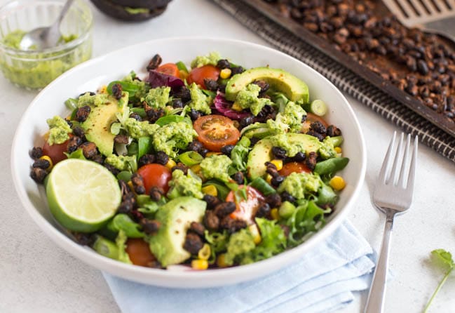 Roasted black bean taco salad with tomatoes and avocado in a bowl