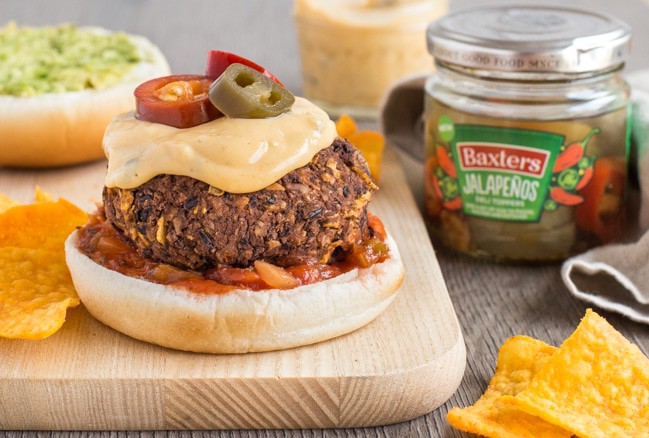 Vegetarian nacho burgers with homemade nacho cheese sauce - these are so good! A simple black bean burger made with crushed tortilla chips and jalapenos, and topped with salsa and avocado. Yum!