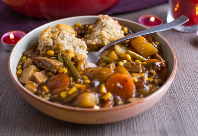 Vegetarian 'beef' stew in a rich gravy, topped with easy suet dumplings - an old recipe from an authentic British mum! Such a brilliant winter warmer.