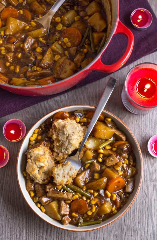 Vegetarian 'beef' stew in a rich gravy, topped with easy suet dumplings - an old recipe from an authentic British mum! Such a brilliant winter warmer.