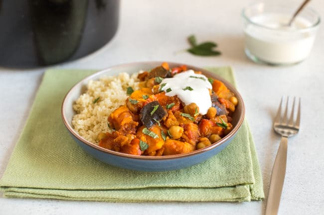 Vegetarian tagine in a bowl served with couscous and topped with yogurt and mint