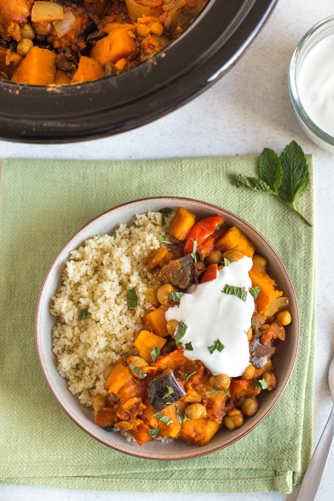 Vegetarian tagine in a bowl served with couscous and topped with yogurt and mint